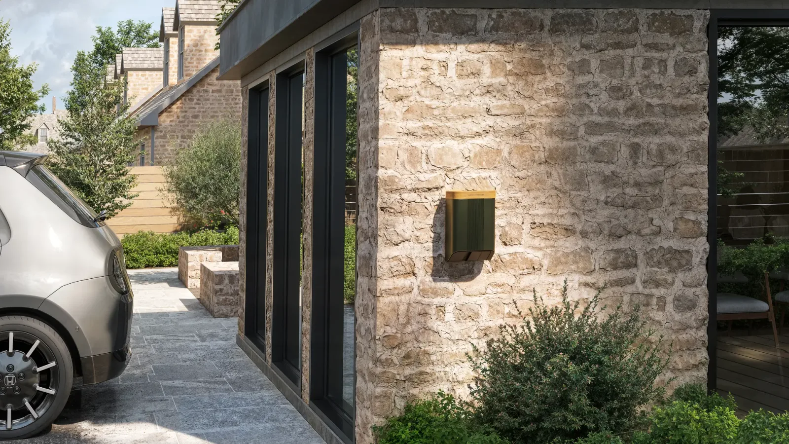 Home Series Wall Mount charger on a stone wall beside a parked car